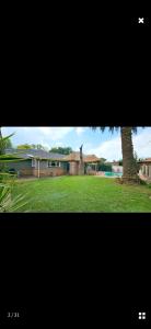 a picture of a house with a tree in a yard at Blackwood Guesthouse in Vereeniging