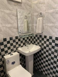 a bathroom with a sink and a toilet and a mirror at Hotel Ludhiana Residency in Ludhiana