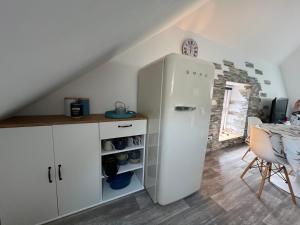 a white refrigerator in a kitchen with a table at Le petit Kichon in Gérardmer +38 photos