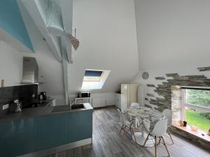 a kitchen with a table and chairs in a room at Le petit Kichon in Gérardmer