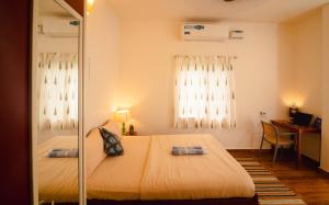 a bedroom with a bed and a desk and window at Odd Table in Mandrem +84 photos