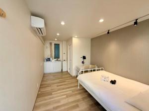 a room with a bed and a kitchen in it at 墨田漢舎3号 in Wada +3 photos