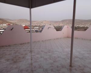 een kamer met witte muren en een tegelvloer bij Zina résidence in Aourir