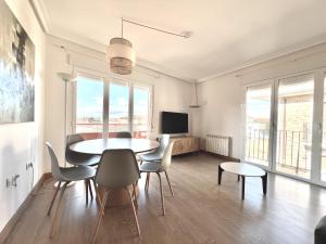 a dining room with a table and chairs and a tv at BaruHaus Duplex Valencia de don Juan 2 in Valencia de Don Juan