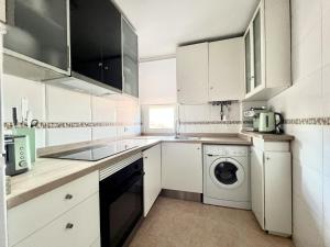 a kitchen with white cabinets and a washing machine at BaruHaus Duplex Valencia de don Juan 2 in Valencia de Don Juan