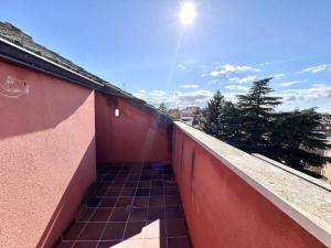 a balcony with a red wall and a tile floor at BaruHaus Duplex Valencia de don Juan 2 in Valencia de Don Juan