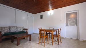 a living room with a table and chairs and a couch at Villa Coleus in Tangalle
