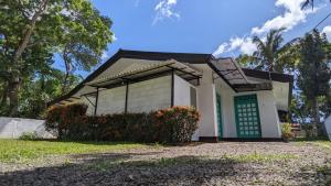 a small white house with a green door at Villa Coleus in Tangalle