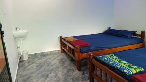 a bedroom with two beds with blue sheets at Sateri Homestay Gokarna Beach in Gokarn