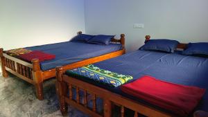 two beds sitting next to each other in a room at Sateri Homestay Gokarna Beach in Gokarn