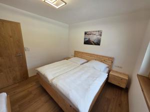 ein Schlafzimmer mit einem Bett mit weißer Bettwäsche und einer Tür in der Unterkunft Bergpanorama Mühlhans in Gallzein