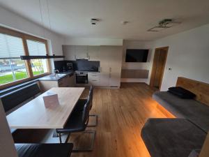 ein Wohnzimmer mit einem Holztisch und einer Küche in der Unterkunft Bergpanorama Mühlhans in Gallzein