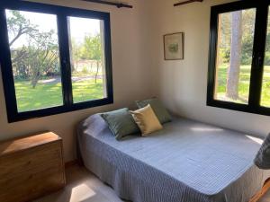 ein Schlafzimmer mit einem Bett mit zwei Fenstern in der Unterkunft La Caballeriza in La Porteña + 87 Fotos