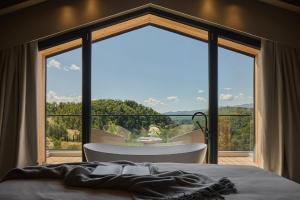 1 dormitorio con ventana grande, bañera y cama en Lo Chalet in Toscana, en Stia