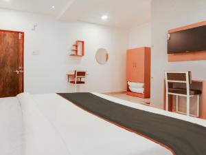 Un dormitorio con una cama y un televisor de pantalla plana. en Super Collection O White Ridge Kamineni, en Hyderabad