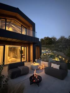 un patio con sofás y una hoguera frente a una casa en Lo Chalet in Toscana, en Stia 14 fotos más