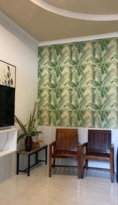 two chairs and a tv in a room with a wallpaper at Lux Hotel Mathiveri in Mathiveri