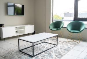 a living room with two chairs and a coffee table at Rosebank Luxury Loft in Johannesburg