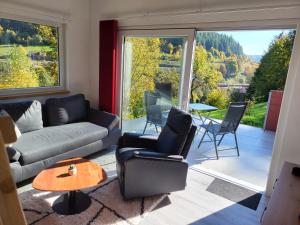 a living room with a couch and chairs and a large window at BlackforestBike&HikeHouse in Baiersbronn +7 photos
