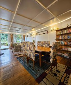 a living room with a wooden table and chairs at THE ENGLISH COTTAGE in Darjeeling