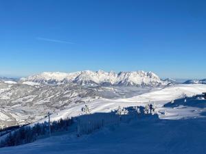 een besneeuwde bergketen met besneeuwde bergen bij Mountainview-Lodge exklusiver Neubau mit Bergblick in Reith bei Kitzbühel