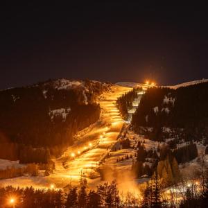 a snowy road with lights on a mountain at night at Modern Gem by Sogn Skisenter in Hafslo
