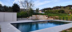 a swimming pool in the middle of a yard at El rincón verde de David y Laura in O Porto de Espasante