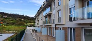 an apartment building with a playground in the background at El rincón verde de David y Laura in O Porto de Espasante