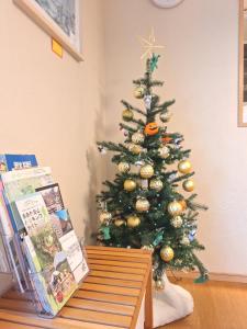 a christmas tree in the corner of a room at Peaceful Garden Home in Ota, Entire 3BR Parking in Ota