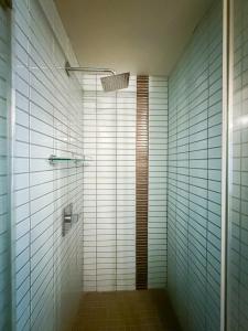 a bathroom with a shower with white tiles at Stylish 2BR Loft with Top-Tier Amenities - 104 - GL in Glendale