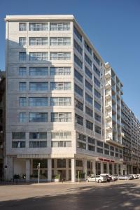 アテネにあるBoss Boutique Athens by Prima Hotelsの大きな白い建物とその前に駐車された車