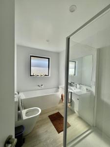 a bathroom with a tub and a toilet and a sink at Room and Private Bathroom in Woodend in Woodend