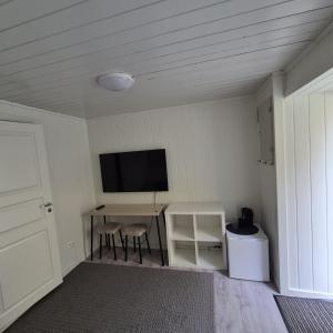 a room with a table and a tv on the wall at Just Sleep Arendal in Arendal +11 photos