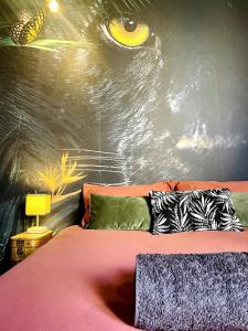 a bedroom with a bed with a painting of an eye at Jungle Chic Apartment, Balneo, Close to center in Belfort