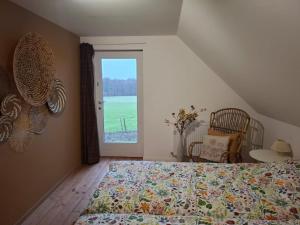 a bedroom with a bed and a large window at Gîte de La Blanche Ferme près de Pairi Daiza in Lessines
