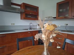 a vase of flowers on a table in a kitchen at Gîte de La Blanche Ferme près de Pairi Daiza in Lessines +22 photos