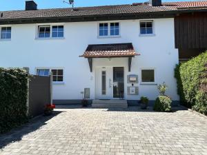 a white house with a brick driveway at Ferienhaus Heiß in Geltendorf