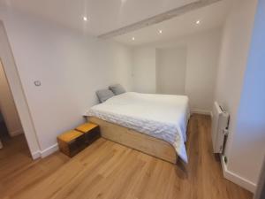 a small bedroom with a bed and a wooden floor at Appartement entier in Izeaux