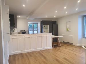 a kitchen with white cabinets and a table in a room at Appartement entier in Izeaux