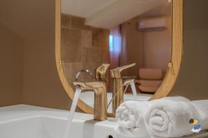 een wastafel met een spiegel en een handdoek bij Dodoterla - BoisBlanc in Sainte-Rose