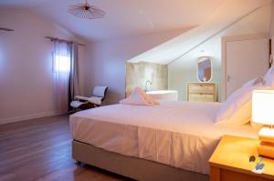 een slaapkamer met een groot bed en een stoel bij Dodoterla - BoisBlanc in Sainte-Rose