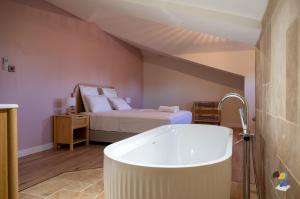 een badkamer met een bad en een bed bij Dodoterla - BoisBlanc in Sainte-Rose