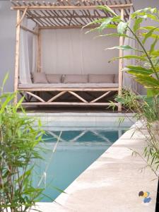 een bed naast een zwembad bij Dodoterla - BoisBlanc in Sainte-Rose