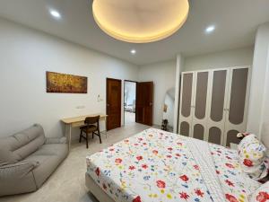 Ban Nong ChaengにあるPalm Garden Villa Aonangのベッドとソファとテーブルのある寝室