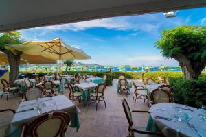 een restaurant met tafels en stoelen en een parasol bij Residence in Capoliveri just 200 mt from the beach in Capoliveri