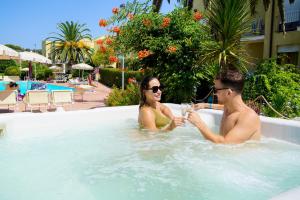 een man en een vrouw zitten in een zwembad bij Residence in Capoliveri just 200 mt from the beach in Capoliveri