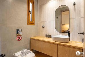un baño con lavabo y espejo en Golden Sun Suites, en Palaiokatoúna