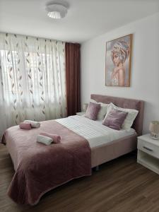 ブラショヴにあるJune's Urban Residenceの大きなベッドとタオル2枚のある寝室