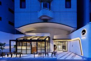 a building with tables in front of it at EN HOTEL Hakata in Fukuoka