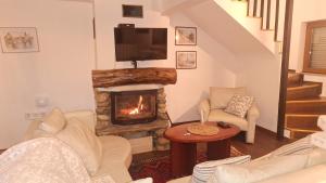 a living room with a fireplace and a television at Beloviski raj 